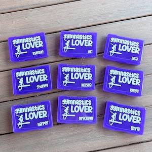 May include: Nine purple rectangular boxes with white text and graphics. Each box reads "Gymnastics Lover" with a gymnast graphic. Each box has a different name: Kynslue, Bri, Lyla, Sydney, Kelsea, Kylee, Harper, Brecklyn, and Emrie.