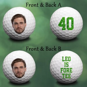 May include: Two white golf balls with green designs. One ball has the number 40 in green glitter. The other ball has the text "LEO IS FORE TEE" in green glitter.