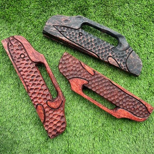 May include: Three wooden handles with a textured surface and a carved design. The handles are in different shades of brown, with one being black.