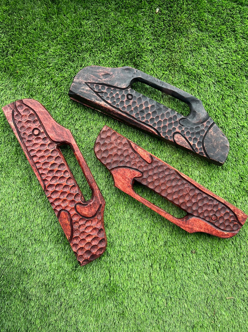 May include: Three wooden handles with a textured surface and a carved design. The handles are in different shades of brown, with one being black.