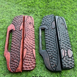 May include: Two wooden fish-shaped door handles, one red and one black, with a textured surface and a small handle on the side. The handles are labeled "SMALL".