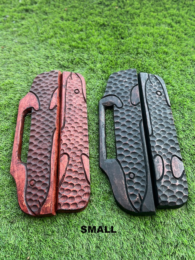 May include: Two wooden fish-shaped door handles, one red and one black, with a textured surface and a small handle on the side. The handles are labeled "SMALL".