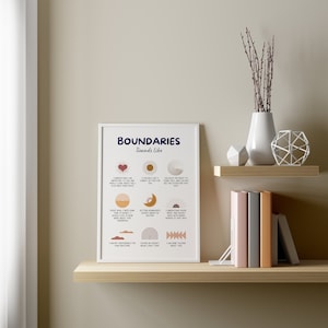 May include: A framed print with the text "BOUNDARIES Sounds like" in navy blue. The print features various icons and phrases in a minimalist style, with a color palette of navy, peach, and brown. The print is displayed on a shelf with decorative items.