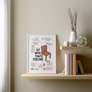 May include: A white framed poster with a colourful illustration of a chair and text that reads "Sit with that feeling". The poster includes tips for managing emotions, such as acknowledging feelings, practicing self-compassion, and validating what you are feeling.