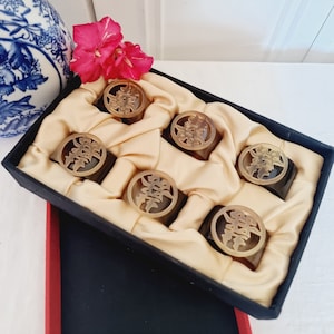 Estuche con 6 Servilleteros Estilo Oriental hechos de Asta, se encuentran sin uso, en su caja original