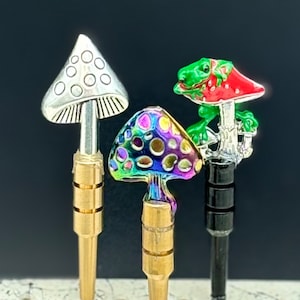 May include: Three decorative mushroom-shaped bottle stoppers. One is silver with white dots, one is iridescent with rainbow colors and white dots, and one is red with a green frog on top.