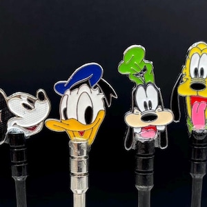 May include: Five colorful metal character figurines of Mickey Mouse, Donald Duck, Goofy, Pluto, and a generic dog. The figurines are attached to metal rods.