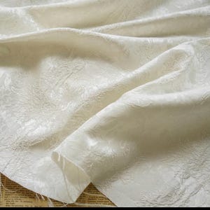 Tissu brocart jacquard de créateur blanc pivoine avec logo en relief au mètre