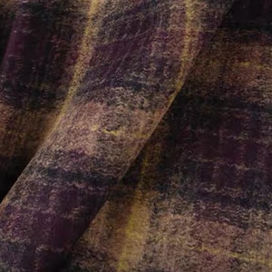 Puede incluir: Primer plano de una tela texturizada con una mezcla de colores. La tela presenta una mezcla de tonos morado oscuro, marrón y amarillo, creando una apariencia moteada. El material está doblado, mostrando la textura y la profundidad del tejido.