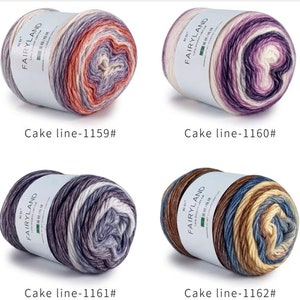 Könnte beinhalten: Vier Knäuel Garn in verschiedenen Farbkombinationen. Jedes Knäuel ist mit "Fairyland" beschriftet und hat eine andere Farbkombination: Orange, Lila und Weiß; Lila, Weiß und Rosa; Grau, Weiß und Lila; und Braun, Blau und Weiß.