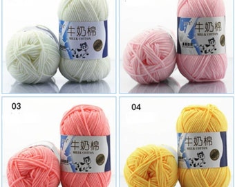 Può includere: Quattro gomitoli di lana in diversi colori: bianco, rosa, pesca e giallo. Ogni gomitolo ha un'etichetta che dice "牛奶棉", che si traduce in "Cotone di latte".