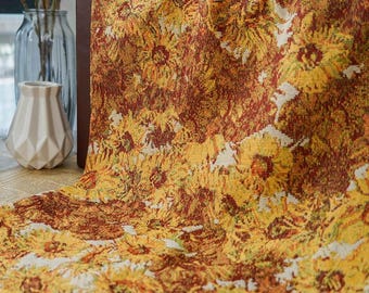 May include: A tapestry throw blanket with a sunflower pattern in shades of yellow, orange, and brown. The blanket is made of a soft, woven fabric and has a fringed edge.