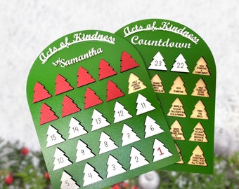 May include: A green wooden countdown board with 23 white Christmas tree shapes, each with a number from 1 to 23. The board is decorated with the words "Acts of Kindness Countdown".