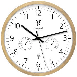 Könnte beinhalten: Eine weiße Analoguhr mit Holzrahmen. Die Uhr hat ein schwarzes Hirschlogo und den Text "Holzwerk". Die Uhr hat außerdem ein Thermometer und ein Hygrometer.