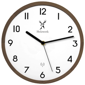 Könnte beinhalten: Eine weiße analoge Uhr mit schwarzen Zeigern und schwarzen römischen Ziffern. Die Uhr hat einen braunen Holzrahmen und ein Hirschlogo mit dem Text "Holzwerk". Die Uhr hat auch ein WLAN-Symbol.
