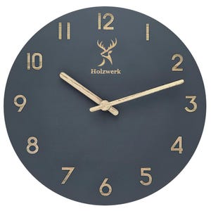 Könnte beinhalten: Eine runde, dunkelblaue Wanduhr mit hellen holzfarbenen Zeigern und Ziffern. Das Zifferblatt zeigt das Wort "Holzwerk" und ein Hirschlogo. Die Ziffern sind in einer einfachen, modernen Schriftart gehalten.