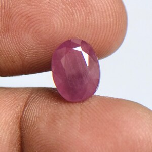 Può includere: Una pietra preziosa ovale di colore rosa con taglio a faccette.