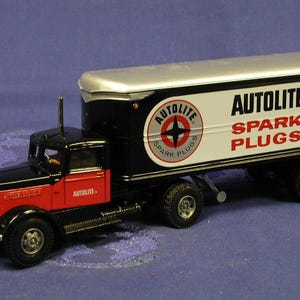 May include: A black and red Autolite Spark Plugs model articulated lorry with a silver trailer. The lorry features the Autolite logo and the year 1939.