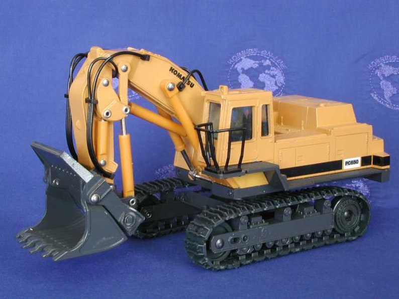 May include: A yellow and gray toy excavator with a black