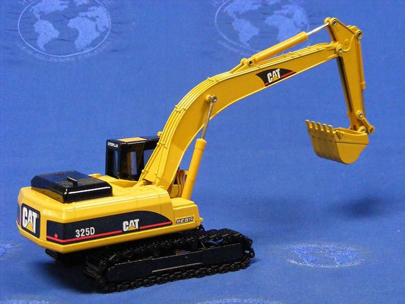 Puede incluir: Modelo de juguete de excavadora Caterpillar 325D amarilla con orugas negras y un brazo levantado. El modelo tiene una cabina negra y una cuchara amarilla.