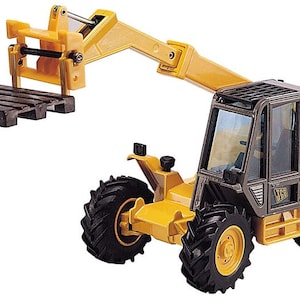 Pode incluir: Um veículo de construção de brinquedo amarelo e preto com um acessório de empilhadeira. O veículo tem uma cabine com um pára-brisas e um logotipo "CAT" preto. O acessório de empilhadeira está levantado e segura uma palete marrom.