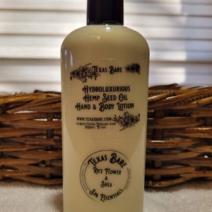 May include: A white plastic bottle of hand and body lotion with a black pump top. The label reads "Texas Bare Hydroluxurious Hemp Seed Oil Hand & Body Lotion" and "Texas Bare Rice Flower & Shea Spa Essentials".