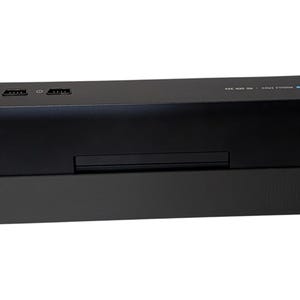 Puede incluir: Un dispositivo electr&oacute;nico rectangular negro con dos puertos HDMI y dos puertos USB en la parte superior. El dispositivo tiene una peque&ntilde;a ranura en la parte delantera y est&aacute; sobre una base negra. El texto "MODULE SPACE" y "HD BEN 32X" es visible.