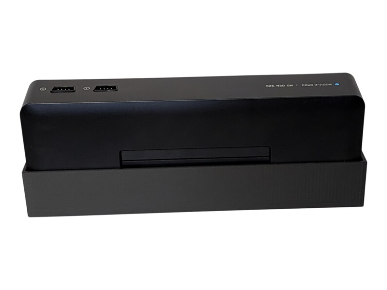 Puede incluir: Un dispositivo electr&oacute;nico rectangular negro con dos puertos HDMI y dos puertos USB en la parte superior. El dispositivo tiene una peque&ntilde;a ranura en la parte delantera y est&aacute; sobre una base negra. El texto "MODULE SPACE" y "HD BEN 32X" es visible.