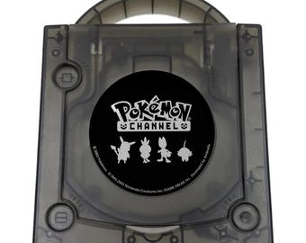 May include: A translucent black GameCube console featuring a circular Pokémon Channel disc cover. The disc displays the white Pokémon Channel logo above silhouettes of Pikachu, Torchic, Meowth, and Pichu, with copyright text along the bottom edge.