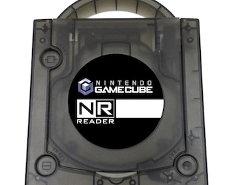 May include: A translucent black Nintendo GameCube NR Reader console featuring a top-loading disc compartment. The center circular label displays the Nintendo GameCube logo above the text NR READER in white lettering on a black background.
