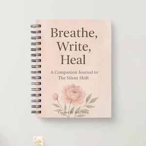 Könnte beinhalten: Ein rosa Spiralbuch mit dem Titel "Breathe, Write, Heal" auf dem Cover. Das Cover zeigt ein Blumenmuster und den Text "A Companion Journal to The Silent Shift" und "Created by Ariel King".
