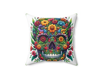 May include: A white cushion featuring a colourful floral skull design. The skull is composed of flowers in shades of pink, red, yellow, orange, purple, and green.