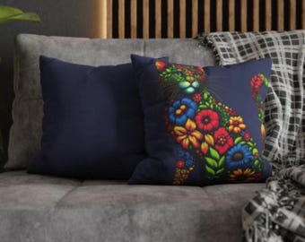 May include: Two decorative throw pillows, one navy blue and one with a floral design of a cat on a navy blue background.