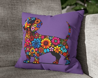May include: A purple cushion with a black dachshund silhouette covered in colourful flowers. The dachshund is facing left and has its tongue sticking out.