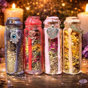 May include: Four glass jars filled with herbs and flowers, each with a unique lid and charm. The jars are arranged on a wooden surface with candles, crystals, and lavender sprigs in the background. The jars have charms with an eye, a rose, a heart, and a wing.