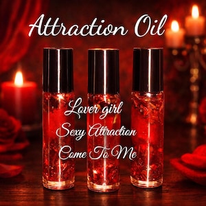 May include: Three clear glass roller bottles filled with red liquid and botanical pieces. The text reads Attraction Oil, Lover girl, Sexy Attraction, and Come To Me. The bottles are set against a dark red background with lit candles and red roses.