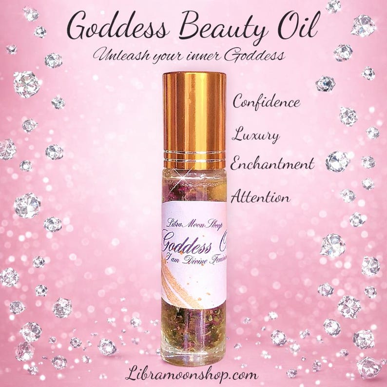 May include: A clear glass roll-on bottle with a gold cap, labelled "Goddess Beauty Oil." The label includes the text "Unleash your inner Goddess," "Confidence," "Luxury," "Enchantment," and "Attention." The background is pink with diamond-shaped sparkles.