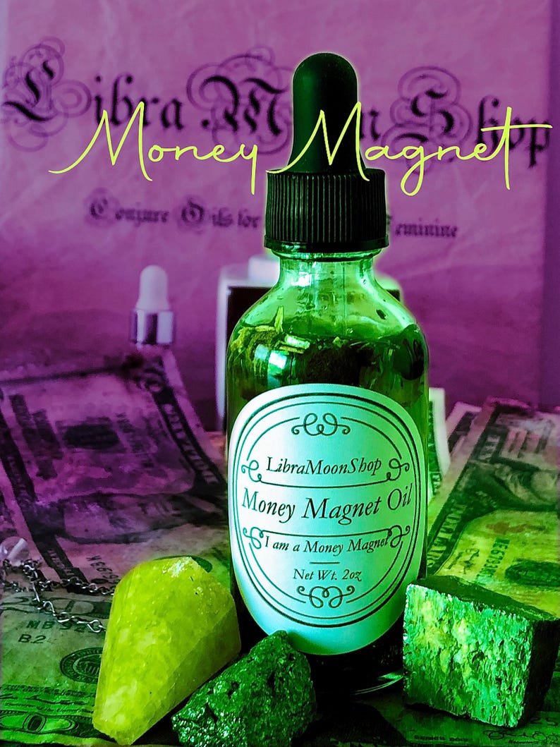 Pode incluir: Uma garrafa de vidro verde de "Money Magnet Oil" com um conta-gotas preto, rotulada "Libra MoonShop". A imagem inclui moeda americana e cristais verdes, com as palavras "Money Magnet" em escrita amarela. Peso l&iacute;quido 57g.