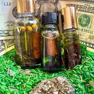 Pode incluir: Tr&ecirc;s frascos de vidro cheios de l&iacute;quido e bot&acirc;nicos, com tampas douradas e pretas. Os frascos est&atilde;o sobre uma cama de arroz verde e rodeados por notas de vinte d&oacute;lares americanos. Uma pedra de pirite est&aacute; em primeiro plano.
