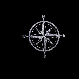 May include: A silver compass with a star design, set against a black background. The compass points north, south, east, and west.