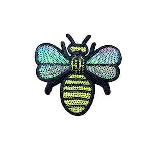 Könnte beinhalten: Eine schwarze und gelbe Biene mit schillernden grünen Flügeln. Die Biene besteht aus Pailletten und ist ein Patch.