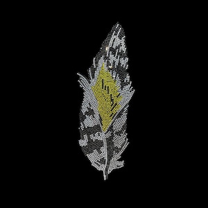 May include: A silver and black feather-shaped design made of rhinestones. The center of the feather is yellow.