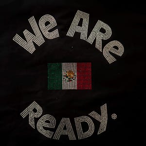 May include: A black fabric garment featuring the text "WE ARE" in silver rhinestones at the top, a central rectangular Mexican flag made of green, white, and red rhinestones, and the text "READY." in silver rhinestones at the bottom.