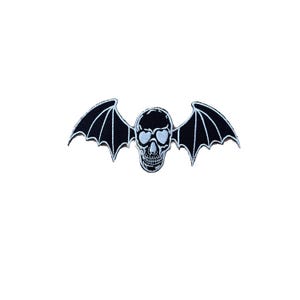 May include: Embroidered patch featuring a skull with bat wings. The skull has light blue accents, including the eye sockets. The wings are black with white stitching. This patch is suitable for jackets, bags, or other fabric items.