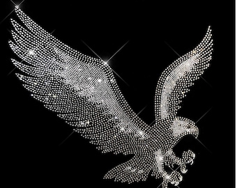 May include: A silver eagle silhouette made of rhinestones on a black background.