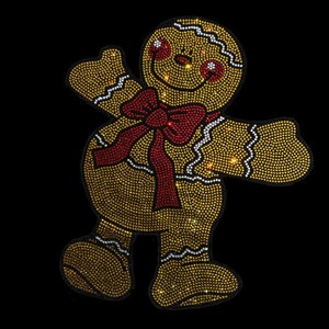 May include: A gingerbread man made of gold and red rhinestones. The gingerbread man is wearing a red bow and has a smiling face.