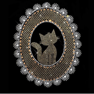May include: A gold and white rhinestone design of a cat sitting inside a circular frame. The cat is outlined in rhinestones and the frame is decorated with a white rhinestone border.