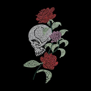 Peut inclure: Un crâne en strass avec une seule rose rouge et deux roses roses sur un fond noir. Le crâne et les roses sont faits de strass.