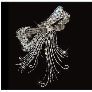 May include: A large silver rhinestone bow with a long, flowing tail. The bow is made of many small rhinestones that are arranged in a pattern to create a bow shape. The tail of the bow is made of many small rhinestones that are arranged in a pattern to create a flowing, cascading effect.