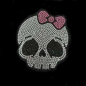 May include: A white skull with black eye sockets and a pink bow on top, made of rhinestones.